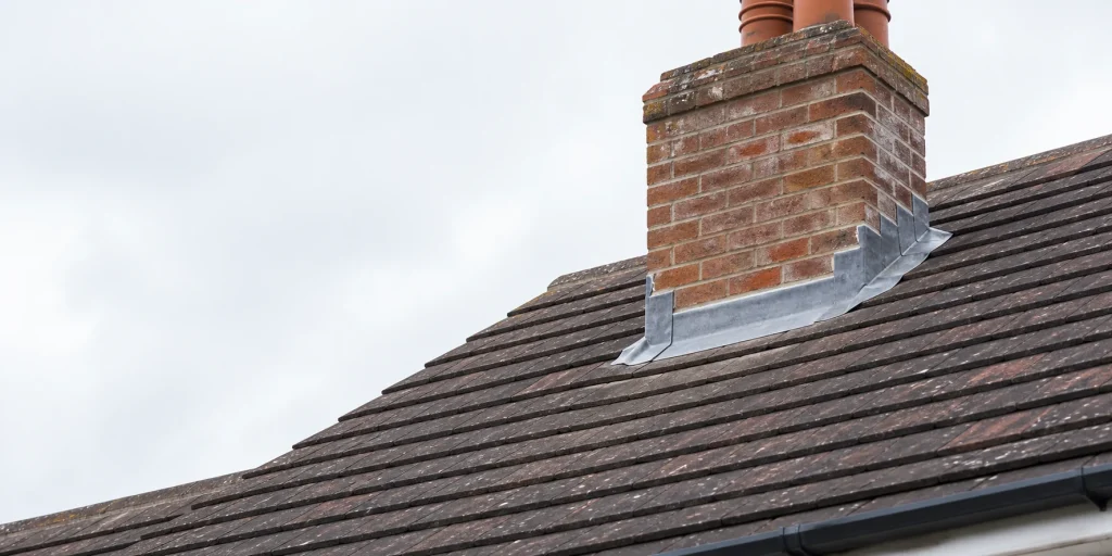 Lead flashing around a tiled roof chimney junction