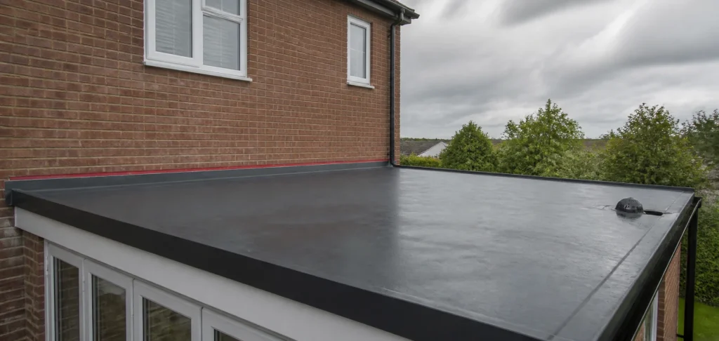 Clean flat roof draining toward an outlet and gutter edge after rain.